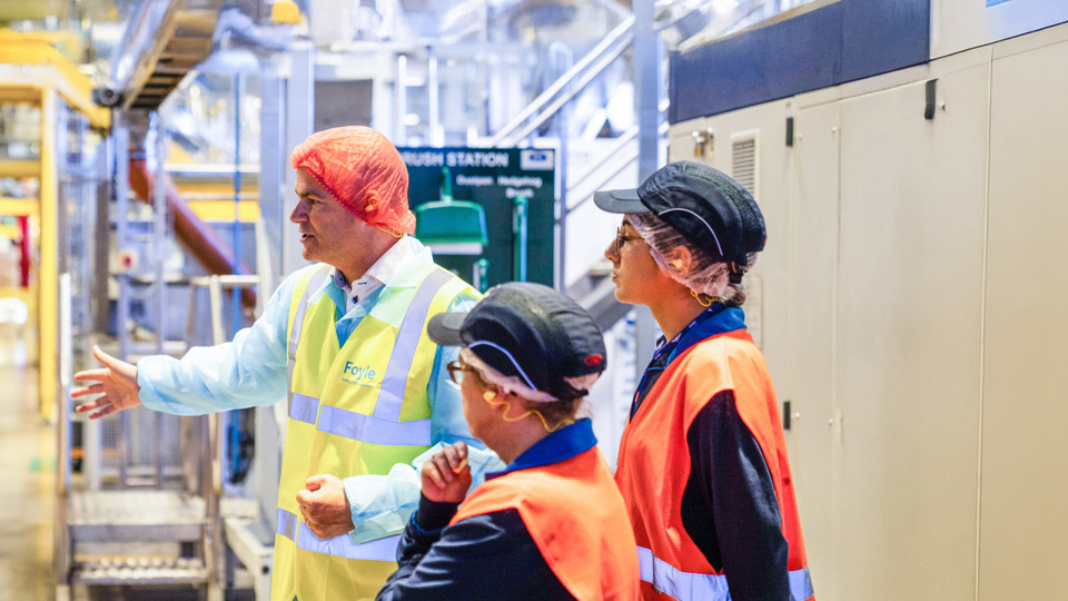 Manager in hairnet and high-vis gesturing to colleagues