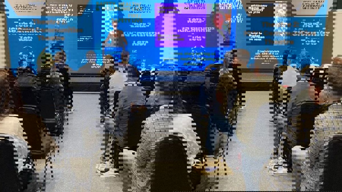 IOSH President Richard Bate presenting from conference stage to audience seated in rows