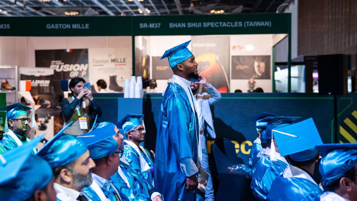 Man in blue cap and gown standing up during IOSH graduation ceremony at Intersec Dubai 2026.