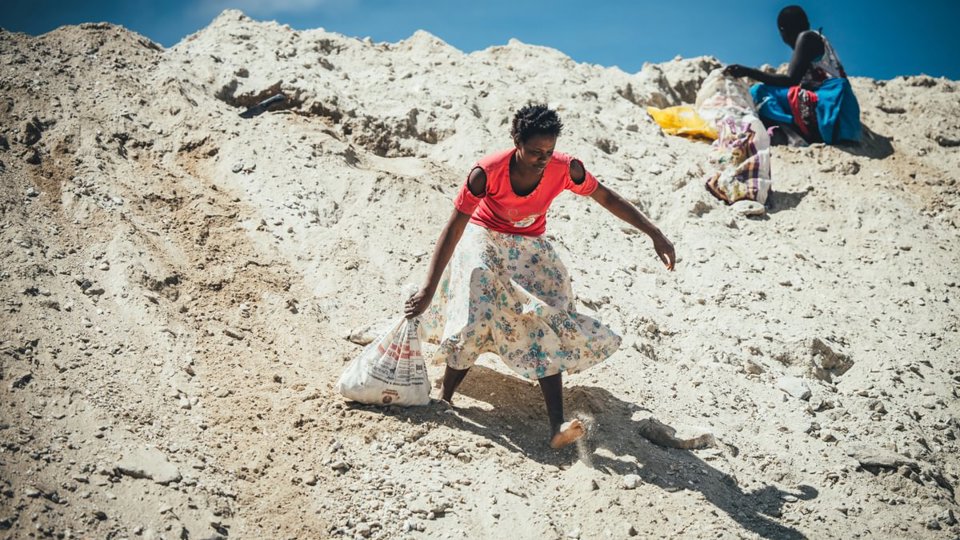 A female quarry scavenger carrying a bag of rocks