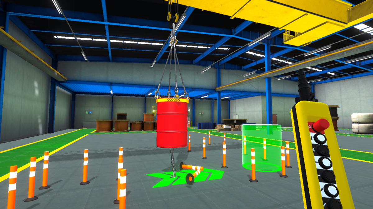 A virtual reality training environment inside an industrial warehouse. The scene shows a suspended red barrel hanging from a yellow overhead crane, surrounded by orange-and-white safety cones arranged in a grid. The floor has green highlighted zones, likely indicating safe or interactive areas. In the background, there are stacked barrels and large rolls of material along the walls under a blue steel frame roof.
