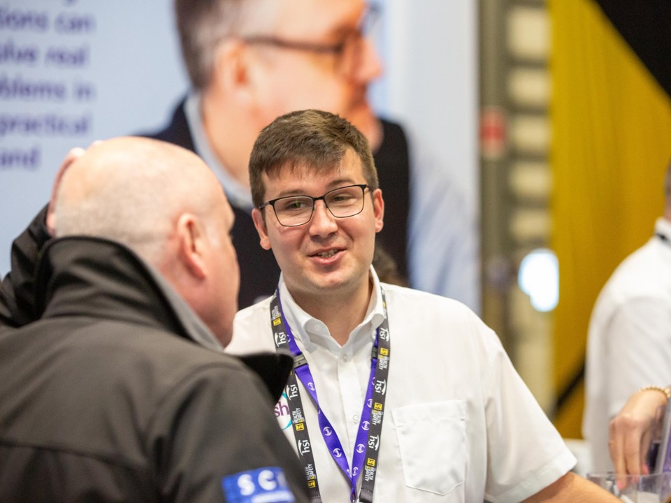 Male IOSH colleague talks to a visitor at our stand during Health and Safety Event 2026