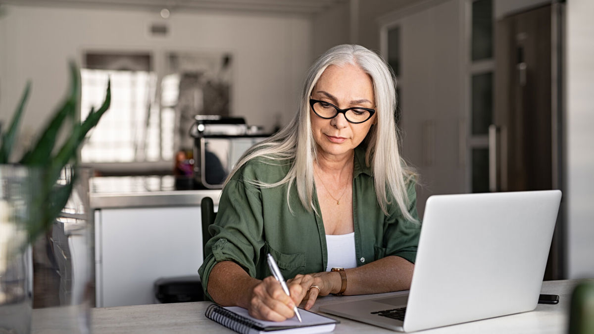 A woman working at her laptop in a home office