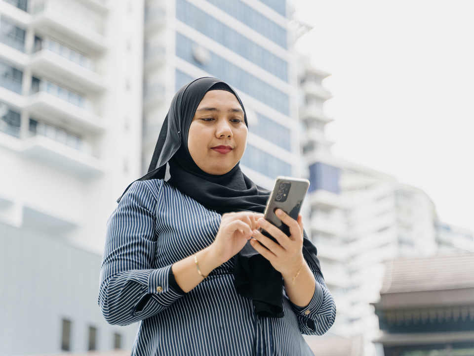 woman outdoors looking at a mobile phone