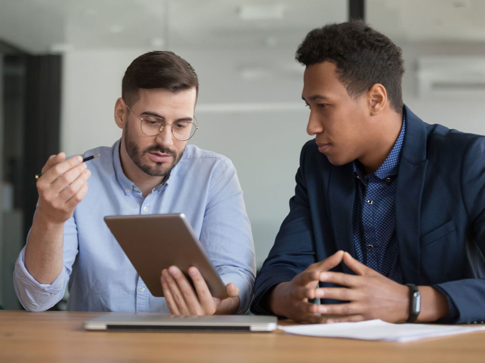 Two men in discussion at a desk