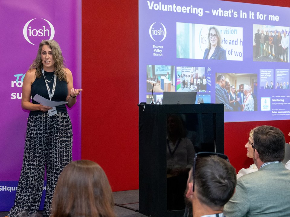 Woman presenting in front of a crowd of people.
