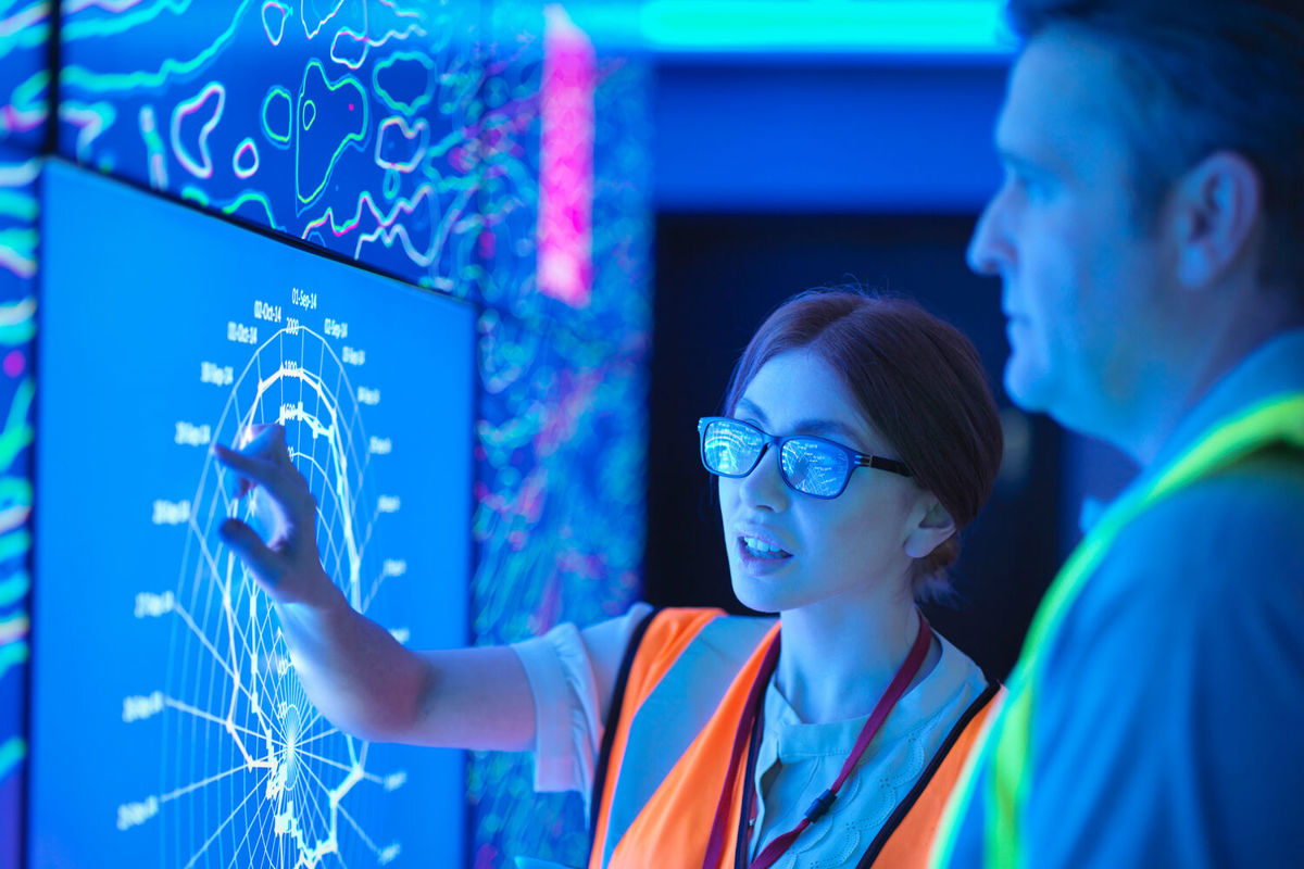 Woman operating high tech touch display in hi viz