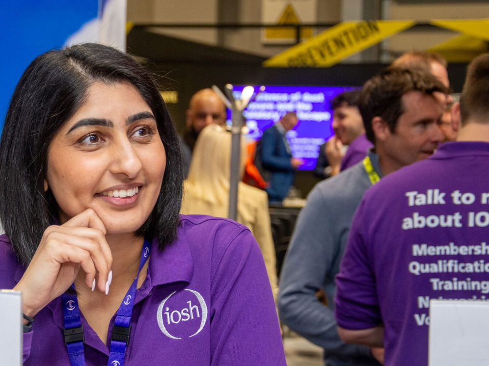 Female member of staff welcoming at IOSH exhibition stand
